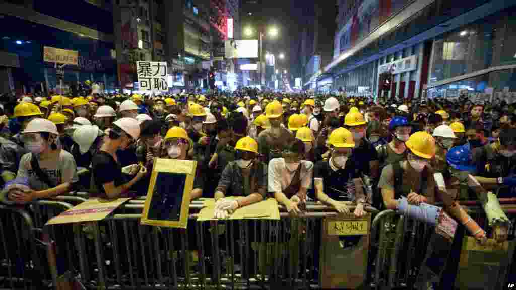 Protesters stand guard behind a barricade at the occupied area in the Mong Kok district of Hong Kong, Oct. 20, 2014. 