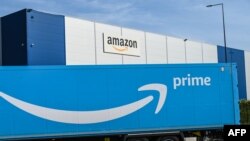 Sebuah truk pengiriman Amazon diparkir di luar pusat logistik Amazon di Lauwin-Planque, Prancis utara, pada 16 April 2020. (Foto: AFP)