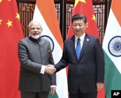 FILE - In this photo released by China's Xinhua News Agency, Indian Prime Minister Narendra Modi, left, and China's President Xi Jinping shake hands as they pose for a photo during a meeting on the sidelines of the BRICS Summit in Xiamen in southeastern China's Fujian Province, Tuesday, Sept. 5, 2017.