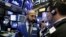 FILE - Specialist Fabian Caceres (L) and trader Michael Capolino confer on the floor of the New York Stock Exchange, Aug. 14, 2018.