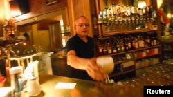 A waiter serves a drink at Cafe Savoy, which is a lesbian, a gay, bisexual and transgender (LGBT) cafe, in Vienna, Austria, Mar. 20, 2013.