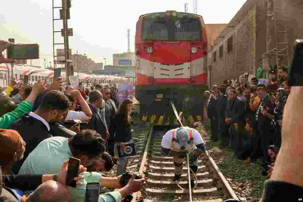 Pegulat Mesir Ashraf Mahrous, yang lebih dikenal sebagai Kabonga, menarik kereta sejauh hampir 10 meter (33 kaki) di Stasiun Ramses di Kairo, dalam upaya mencetak Rekor Dunia Guinness. (AP) 