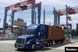 A truck prepares to drop off its container and take another at the Long Beach Container Terminal in Long Beach, California, U.S., April 20, 2023. (REUTERS/Mike Blake)