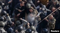 Radical protesters, including supporters of the All-Ukrainian Union Svoboda (Freedom) Party, clash with law enforcement members during a rally near the parliament building in Kyiv, Oct. 14, 2014.