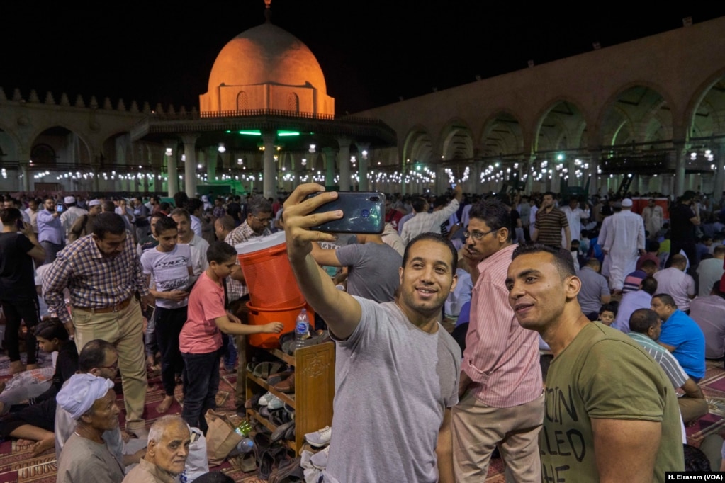 After the end of the rituals, Muslims pose for a selfie in Amr Ibn al-As mosque, in old Cairo, Egypt, May 31, 2019. 