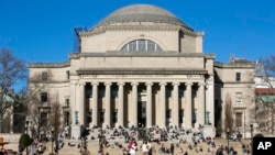 FILE - Students relax on the front steps of Low Memorial Library on the Columbia University campus in New York City on Feb. 10, 2023. 