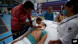 Three-year-old Uziel kisses his father Ivan Dominguez Diaz, 27, who is awaiting surgery for a broken neck, Mexico.