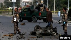 Petugas keamanan menyelidiki lokasi serangan bom di Kabul (21/6).