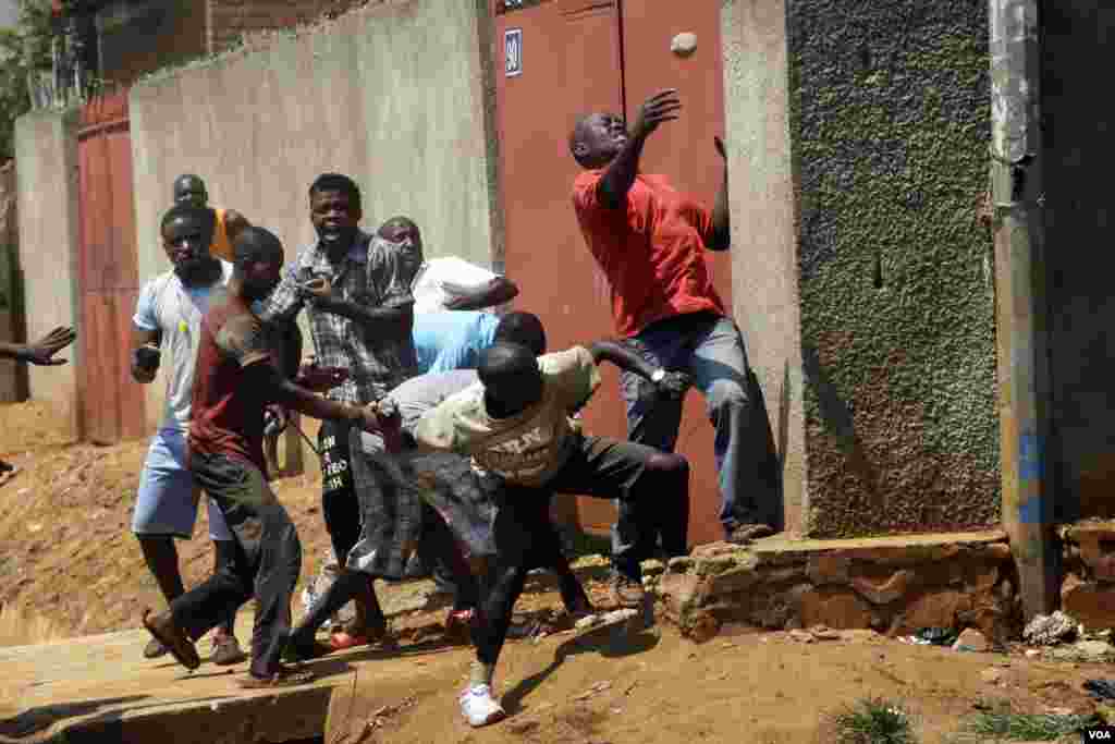Protesters throw stones at police during clashes in the Nyakabyga neighborhood of Bujumbura, May 21, 2015.