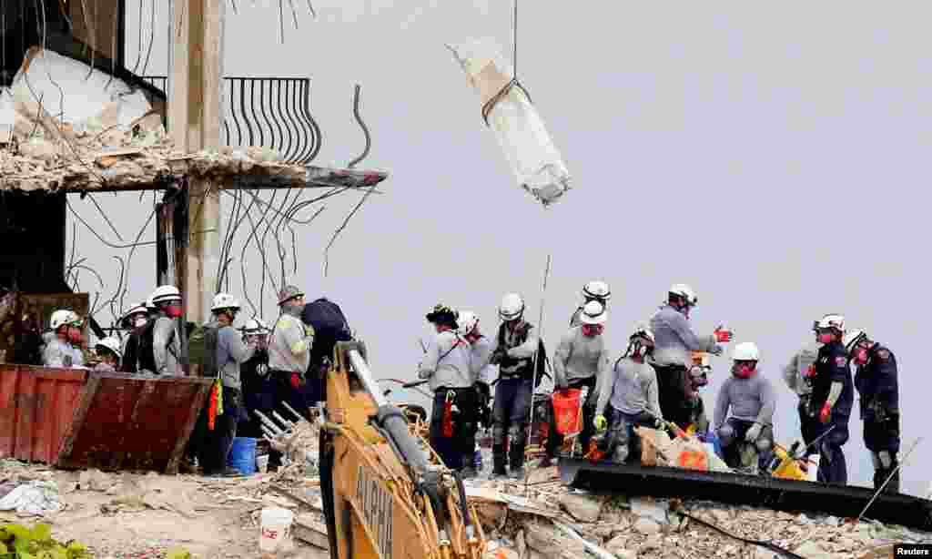 Emergency workers conduct search and rescue efforts at the site of a partially collapsed residential building in Surfside, near Miami Beach, Florida, June 30, 2021.