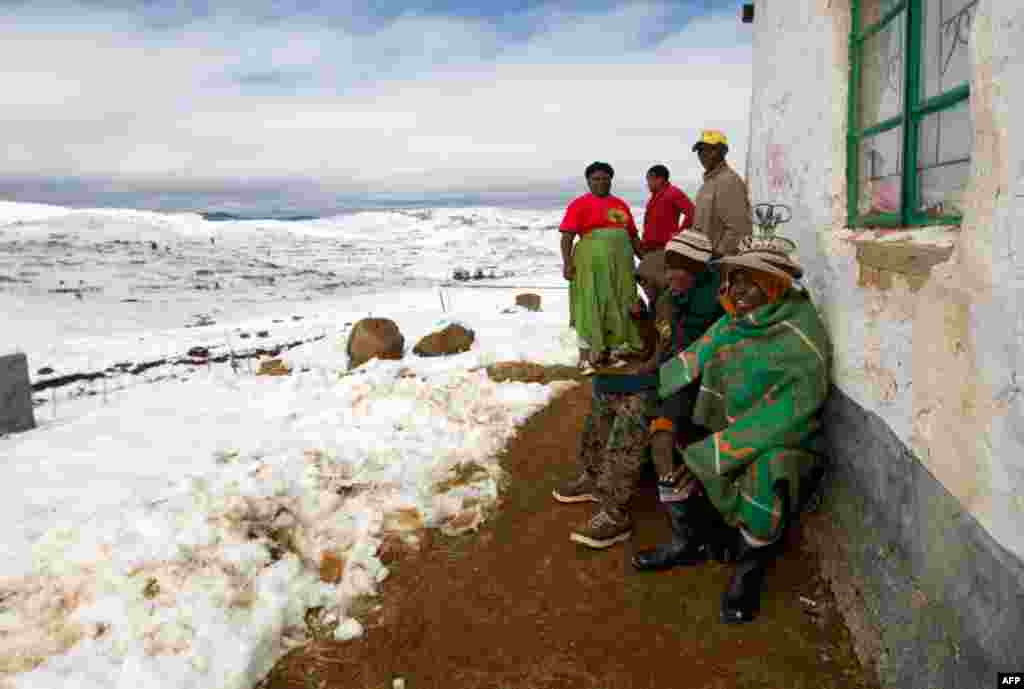 July 27: Residents surrounded by snow look out from their home near Mountain Ayliff. Several major routes throughout South Africa were closed traffic after the snowfall. REUTERS/Rogan Ward