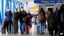 Travelers walk through Terminal 1 at O'Hare International Airport in Chicago, Dec. 30, 2021.