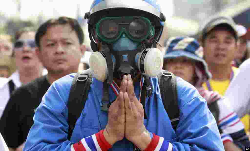 A man prays as he and colleagues confront police during an operation to reclaim government offices occupied by anti-government protesters on the outskirts of Bangkok, Feb. 14, 2014.