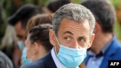 FILE - Former French president Nicolas Sarkozy, wearing a face mask, attends a ceremony in Nice, Nov. 7, 2020.