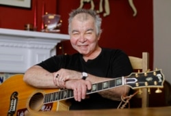 FILE - John Prine poses in his office in Nashville, Tennessee, June 20, 2017.