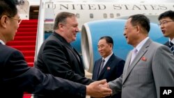 Državni sekretar SAD, Mike Pompeo, pozdravlja se sa sjevenokorejskim Direktorom Odjeljenja za ujedinjeni front, Kim Jong Čolom (centar) i ministrom inostranih poslova Sjeverne Koreje Ri Jog Hoom, drugim s desna, nakon što je sletio na međnarodni aerodrom Sunan, u Pjongjangu, Sejverna Koreja, 6. jula 2018.