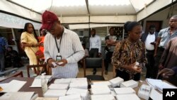 FILE: Electoral officials checks permanent voters cards at a distribution centre ahead of Feb. 2023 Presidential elections in Lagos, Nigeria, Wednesday, Jan. 11, 2023. 