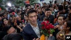 Thanathorn Juangroongruangkit, center, leader of the Future Forward Party is surrounded by his supporters as he arrives at Constitutional Court in Bangkok, Thailand, Nov. 20, 2019. 