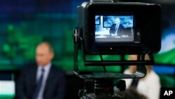 Le président russe Vladimir Poutine devant une camera de Russia Today à Moscou, Russie, le 11 juin 2013.