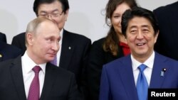 俄羅斯總統普京(左)12月16日與日本首相安倍(右)在東京。