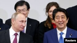 FILE - Russian President Vladimir Putin (L) and Japanese Prime minister Shinzo Abe attend a Japanese-Russian meeting in Tokyo, Japan, Dec. 16, 2016.