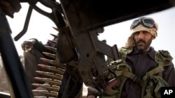 Libyan rebels who are part of the forces against Libyan leader Moammar Gadhafi sits on a truck with a heavy machine gun after capturing the oil town of Ras Lanuf, in eastern Libya, March 5, 2011
