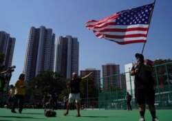 An anti-government protester waves the U.S. flag before the start of the rally "Reclaim Tuen Mun" in Tuen Mun district, in Hong Kong, Sept. 21, 2019.