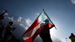 Una persona sostiene una bandera puertorriqueña durante una marcha para conmemorar el día Internacional de la Mujer, en San Juan, Puerto Rico, el 8 de marzo de 2024. REUTERS/Ricardo Arduengo