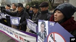 Activists chant slogans during a news conference denouncing U.S. sanctions on Iran in front of the foreign ministry, where the U.S. State Department's special adviser for nonproliferation and arms control, Robert Einhorn is to meet South Korean Deputy For
