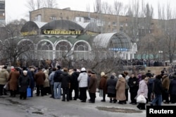 FILE - Local residents wait in a queue to get humanitarian aid near a grocery store in Donetsk, Jan. 29, 2015.
