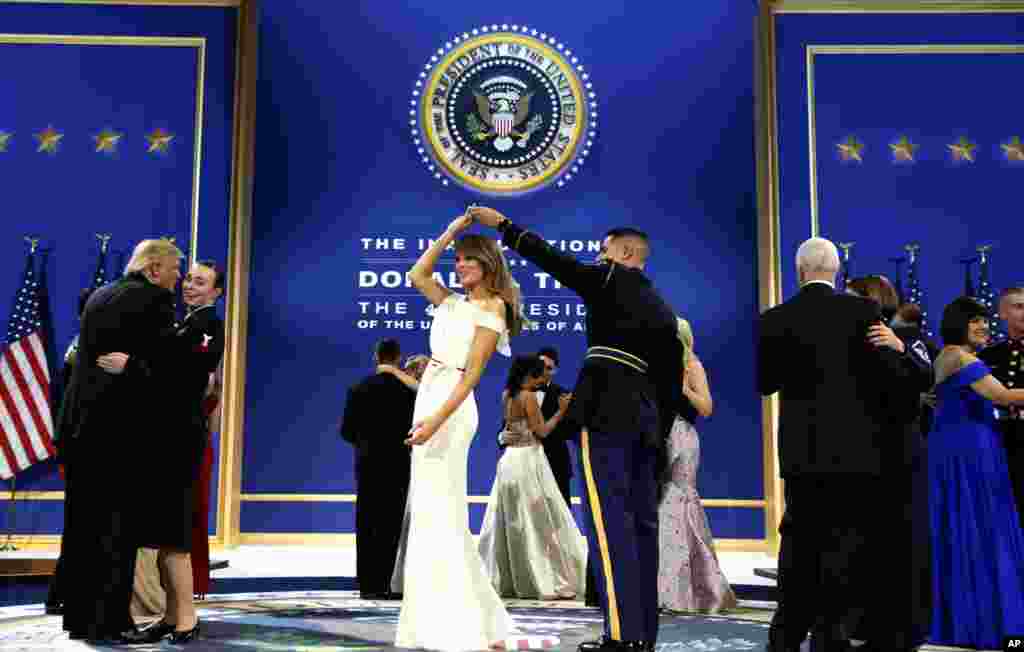 President Donald Trump, left, dances with Navy Petty Officer 2nd Class Catherine Cartmell as first lady Melania Trump is spun by Army Staff Sgt. Jose A. Medina during a dance at The Salute To Our Armed Services Inaugural Ball in Washington, Jan. 20, 2017.