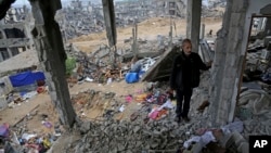 A Palestinian man stands in rubble of his house which was destroyed during the conflict between Israel and Hamas, in Gaza City's Shijaiyah neighborhood, Nov. 24, 2014.