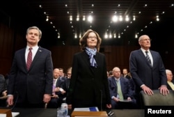 FBI Director Christopher Wray; CIA Director Gina Haspel and Director of National Intelligence Dan Coats arrive with other U.S. intelligence community officials to testify before a Senate Intelligence Committee hearing on "worldwide threats" on Capitol Hill, Jan. 29, 2019.
