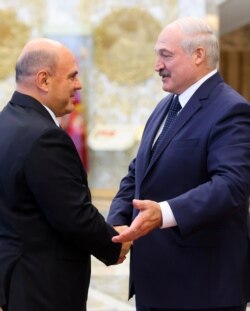 Russian Prime Minister Mikhail Mishustin, left, shakes hands with Belarusian President Alexander Lukashenko prior to their talks in Minsk, Belarus, Sept. 3, 2020.