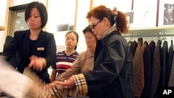 Local shoppers take a look at clothing in a Burberry store on in Shanghai, China. (file photo)