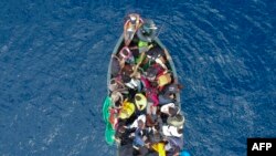 FILE: An aerial photo shows a boat carrying migrants stranded in the Strait of Gibraltar before being rescued by the Spanish Guardia Civil and the Salvamento Maritimo sea search and rescue agency that saw 157 migrants rescued. Taken 9.18.2018