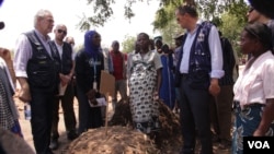 EU Commissioner Christos Stylianides (L) learns about a manure re-purposing initiative launched by the local community in Chikwawa district. (L. Masina/VOA)