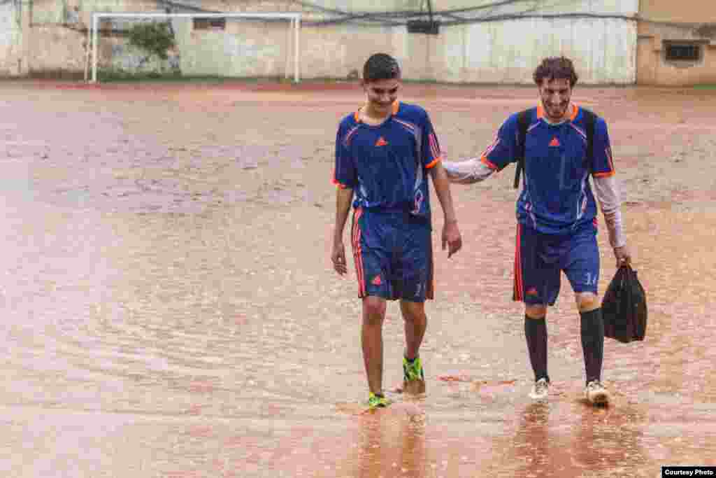 Players abandon a match before half time due to the heavy rain, Lebanon, Dec. 2, 2014. (John Owens/VOA)