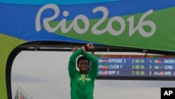 Silver medalist Ethiopia's Feyisa Lilesa, crosses his arms as he celebrates on the podium after the men's marathon at the 2016 Summer Olympics in Rio de Janeiro, Brazil, Sunday, Aug. 21, 2016. 