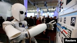 A robot operates a switchboard during a demonstration at a science fair.