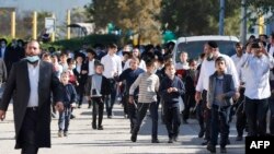 Anak-anak dari komunitas Yahudi ultra-Ortodoks Israel berjalan di luar sekolah Talmud Yahudi di kota Ashdod yang melanggar aturan lockdown, 22 Januari 2021. (Foto: JACK GUEZ / AFP)