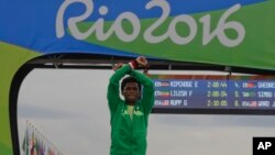 FILE - Silver medalist Ethiopia's Feyisa Lilesa, crosses his arms as he celebrates on the podium after the men's marathon at the 2016 Summer Olympics in Rio de Janeiro, Brazil, Aug. 21, 2016. 