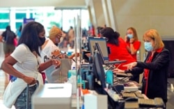 FILE - Travelers check in at Love Field airport, May 28, 2021, in Dallas.