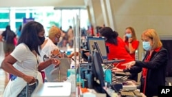 Travelers check in at Love Field airport, May 28, 2021, in Dallas. 