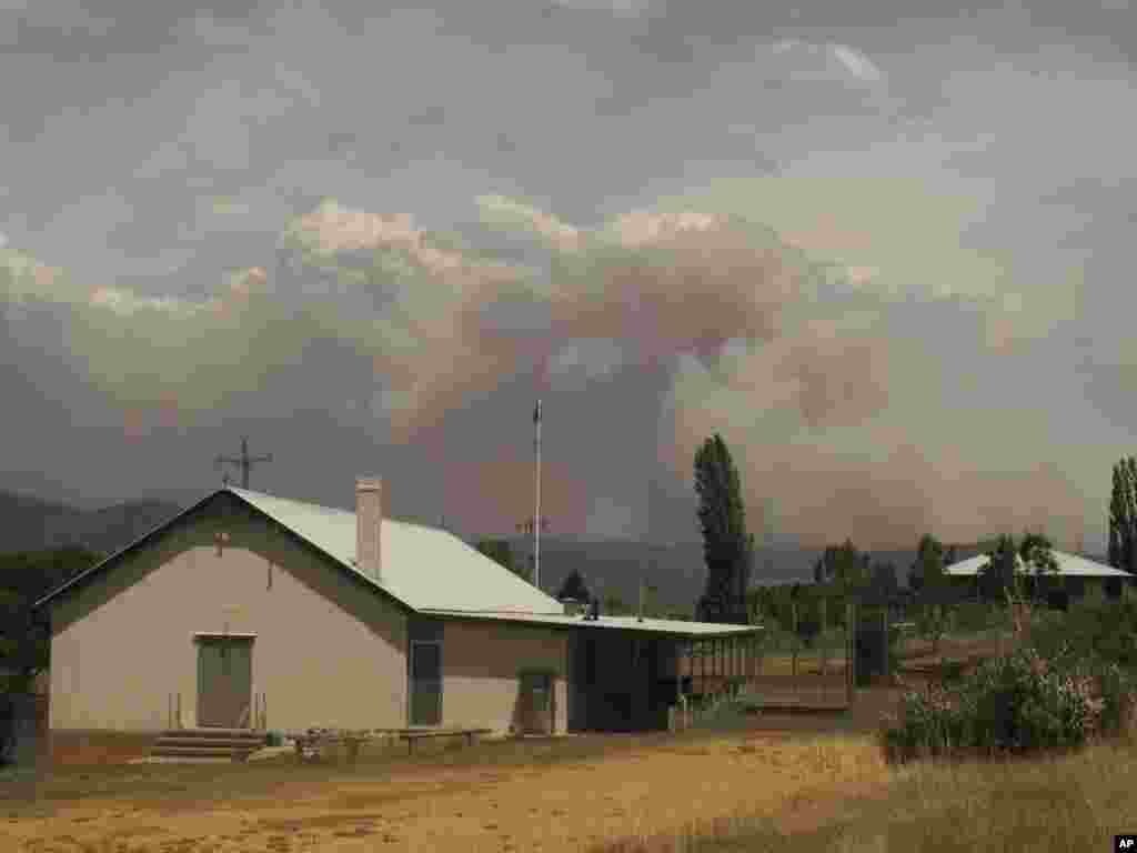 Wildfire smoke rises from hills behind the village of Numeralla in New South Wales state, Australia, January 8, 2013.