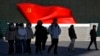 People walk past a sculpture of the Chinese Communist Party flag at the Museum of the Communist Party of China, in Beijing, Jan. 14, 2025. 