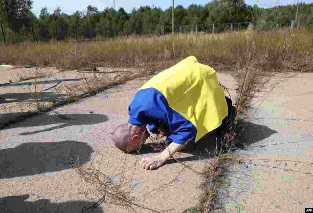 Seorang prajurit Ukraina melakukan sujud ke tanah setelah dibebaskan dari tawanan Rusia di lokasi yang dirahasiakan di dekat perbatasan Ukraina-Belarusia. (AFP)&nbsp;