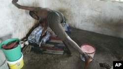 FILE - A patient from the Holy Ghost Mental Home tries to reach out, whilst chained to his bed, in Monrovia, Liberia, Aug. 29, 2003.