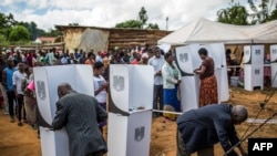 
Les électeurs s'acquittent de leur devoir citoyen dans un bureau de vote à Mzuzu, au Malawi, lors des élections générales du 21 mai 2019.
