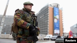 FILE - A Belgian soldier, one of hundreds deployed to guard potential terror targets, stands outside the European Commission headquarters in Brussels, Jan. 21, 2015. 